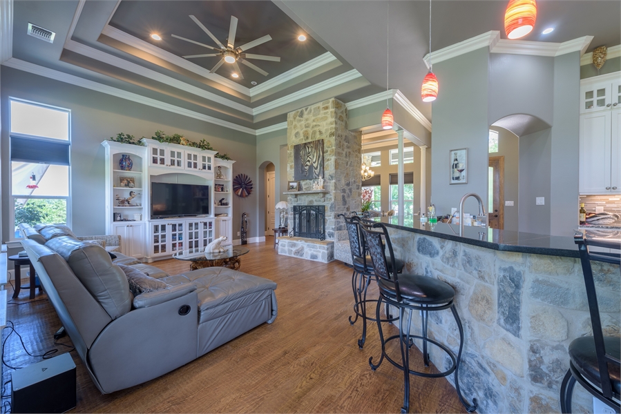 Family Room Featuring Tray Ceiling & Double Sided Fireplace image of Vita Encantata House Plan